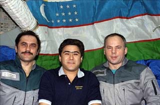 Vinogradov, Sharipov and Solovyev, float before an Uzbeck flag hanging on the Base Block of the Mir Space Station during STS-89. 